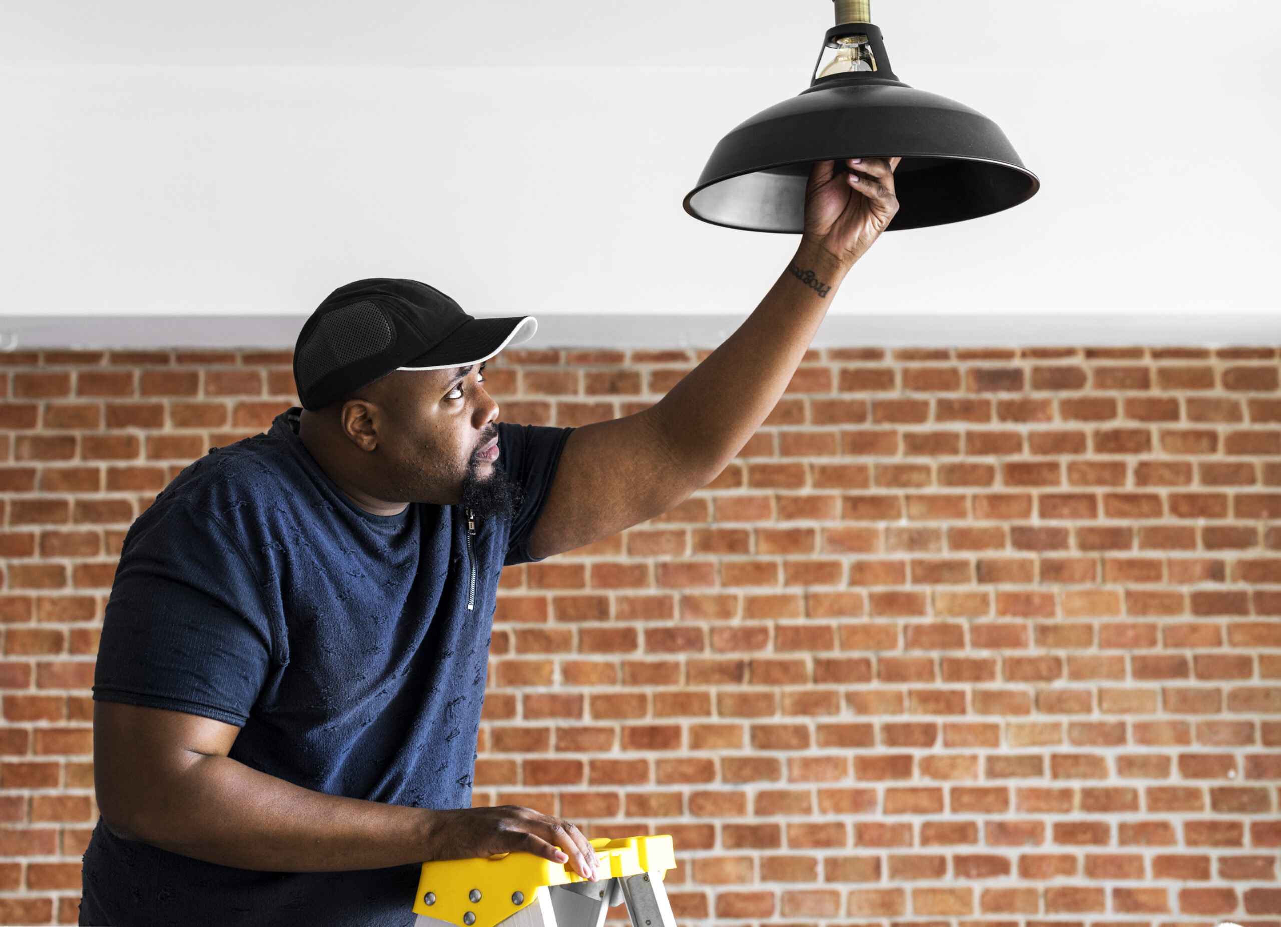 Black guy installing light bulb